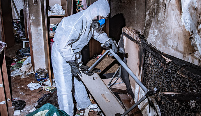 A person is repairing fire damaged room