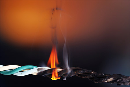 An electrical wire on fire due to overloading or short circuit