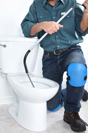 A plumber fixing a toilet