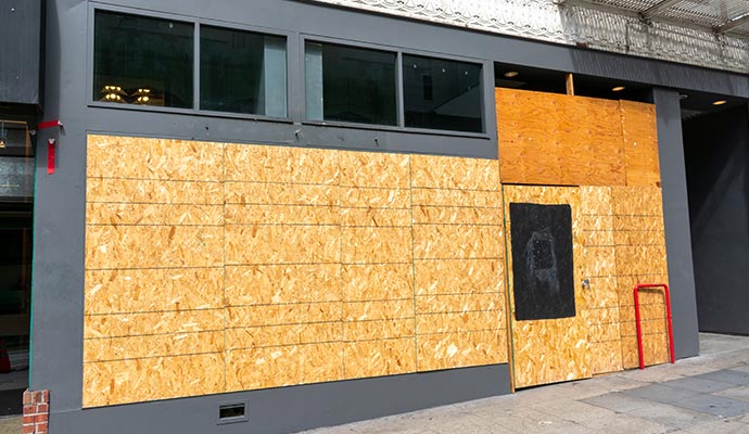 Commercial building entrance boarded up after disaster