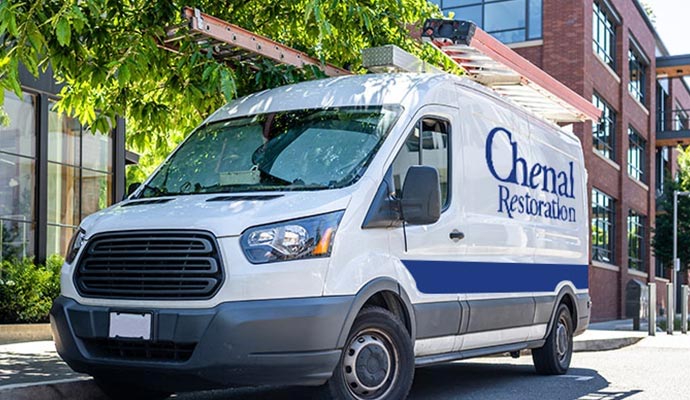 Chenal Restoration service van equipped with ladders parked on street