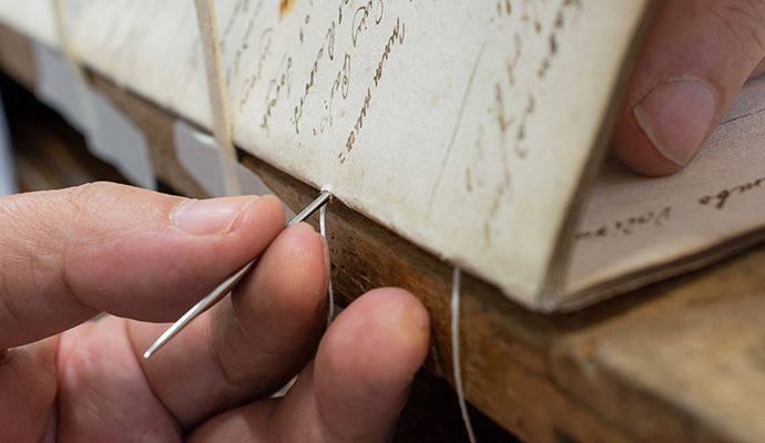 Document restoration by sewing Hand sewing process to repair damaged paper documents