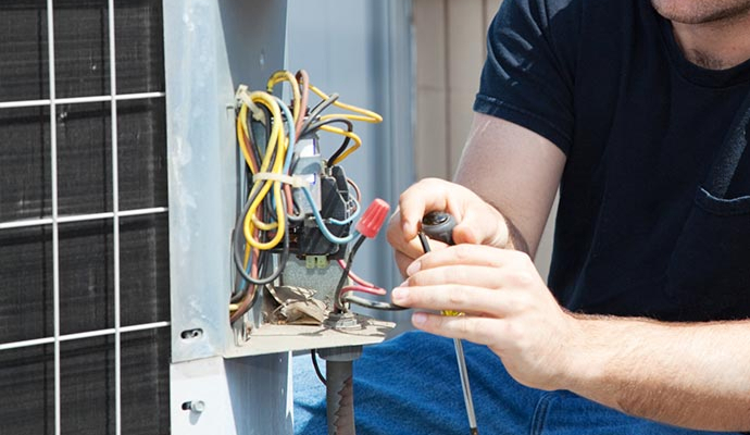 HVAC technician repairing a damaged discharge line on an air conditioning system