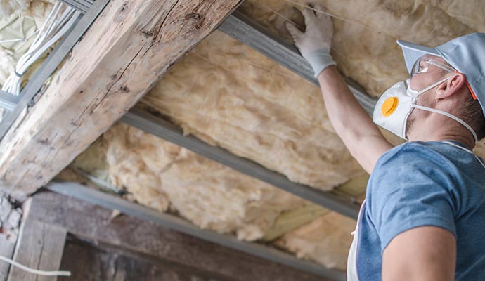 A person is installing attic insulation A person is installing attic insulation