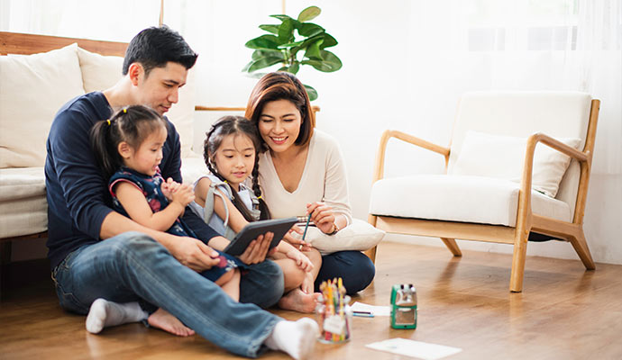 A happy family sitting on living room floor