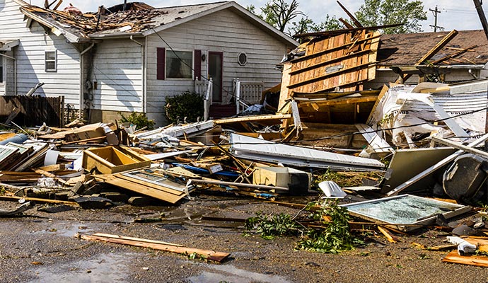 Hurricane damaged property with collapsed roof and debris Property damaged by a hurricane with a collapsed roof and debris scattered around
