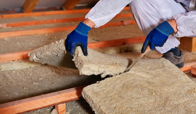 Expert replacing thick insulation material in a building