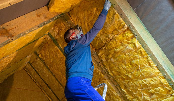A person is replacing roof attic insulation A person is replacing roof attic insulation