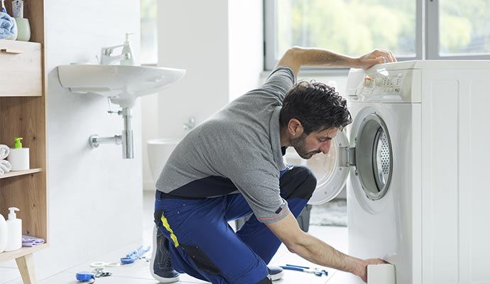 A repairman is fixing washing machine