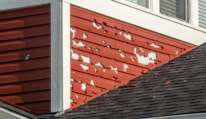 Hail damage red vinyl siding
