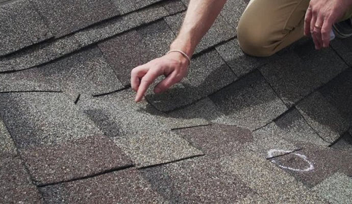 Professional inspecting hail damaged roof