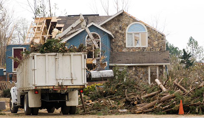 Residential property storm damage cleanup with service truck