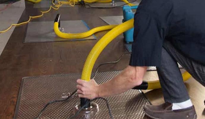Technician using drying system for water damaged floor