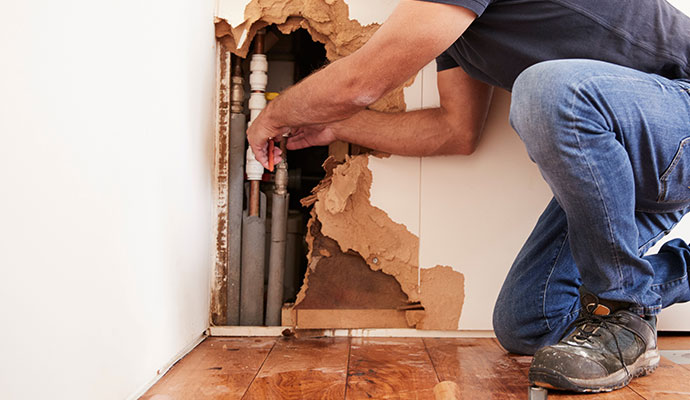 Water pipe repairing service behind damaged wall