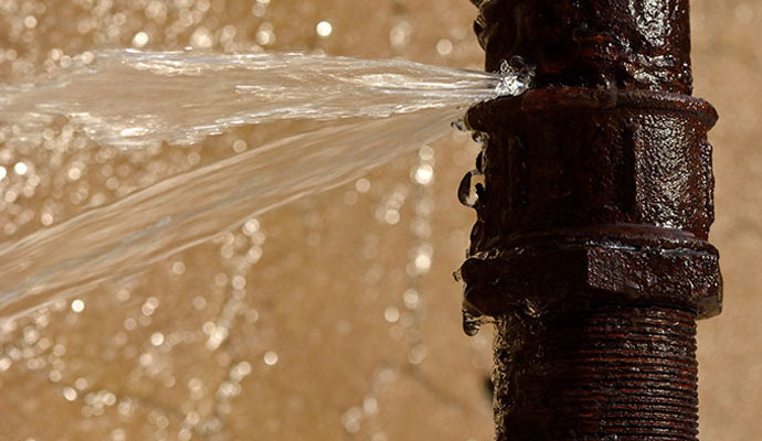 Water leaking from a burst rusty water pipe